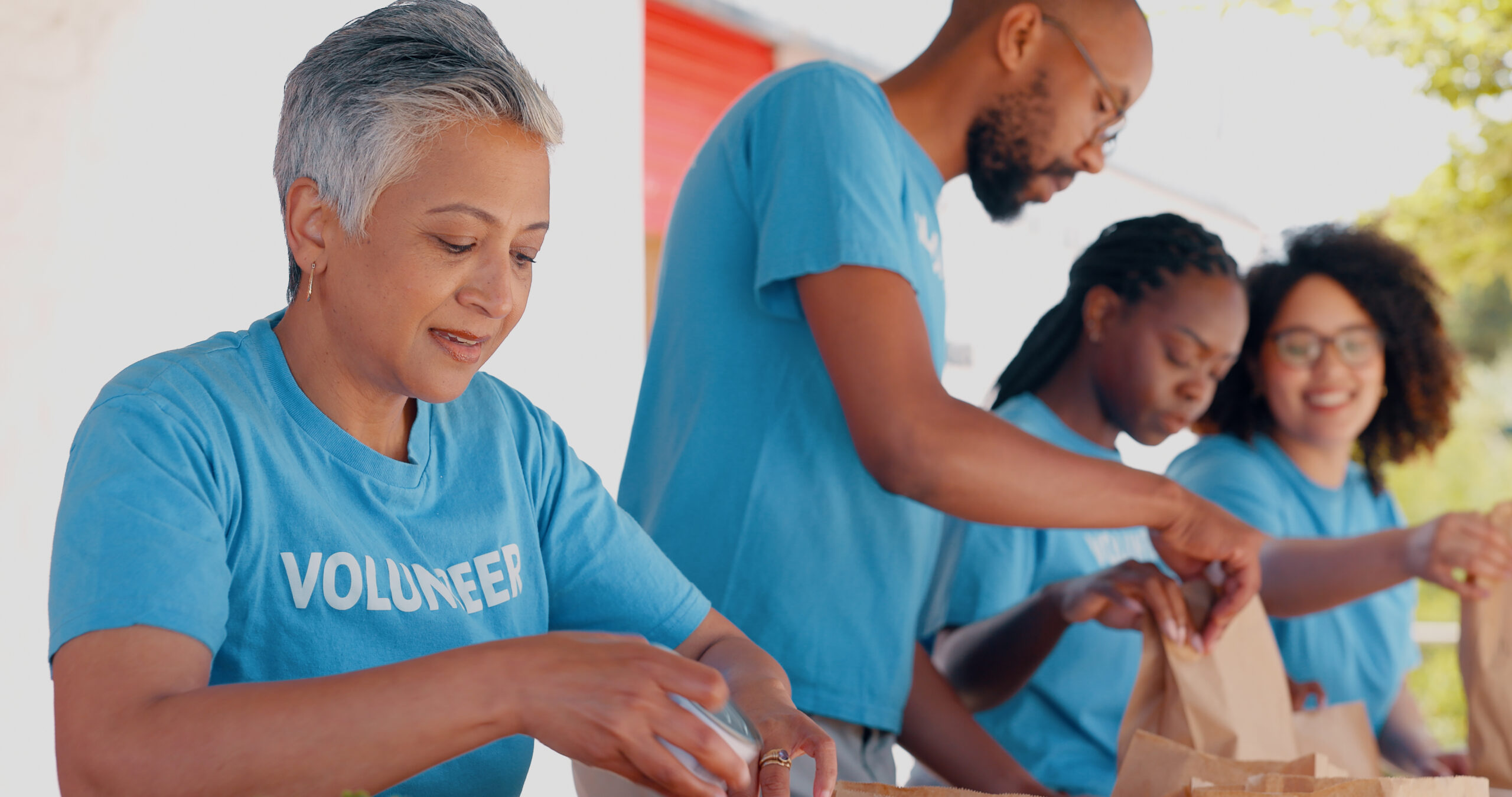 People volunteering, packaging food and donation for community service, poverty support and NGO man.
